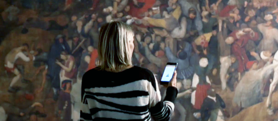 Frau mit Handy vor einem Wandgemälde