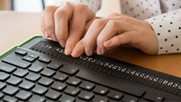 Blinder Mensch arbeitet mit spezieller PC-Tastatur