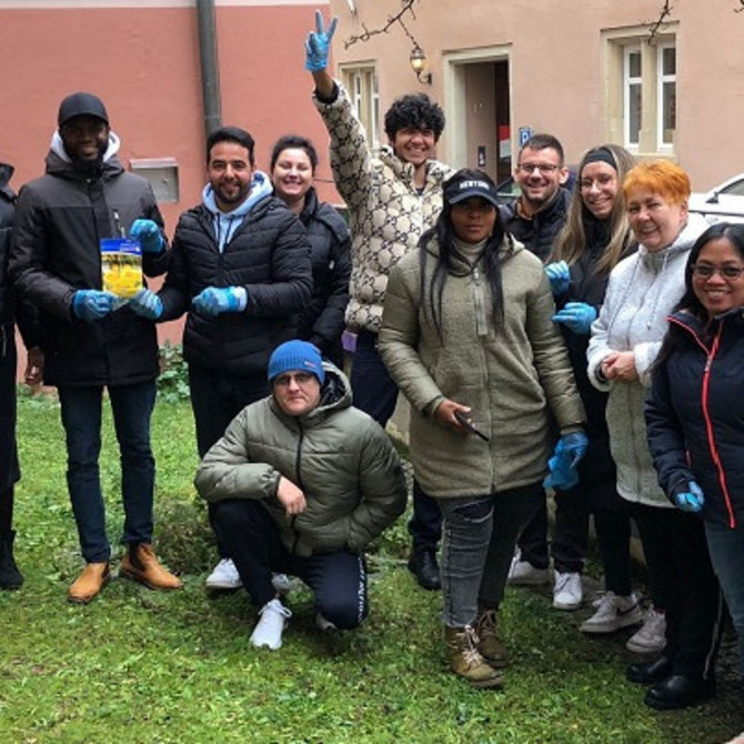 Eine Gruppe Lernender steht in einem Garten