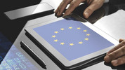 Tablet liegt auf einem Tisch mit einer EU-Flagge