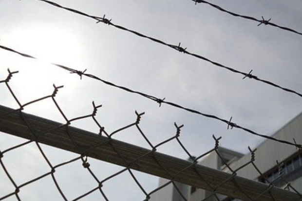 Blick von unten auf einen Stacheldrahtzaun