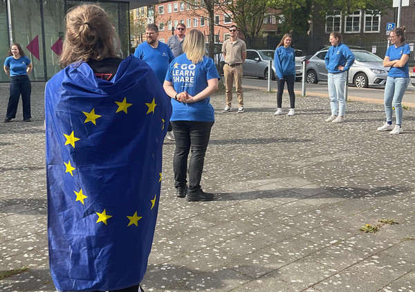 Teilnehmende am EuroApprentices-Treffen stehen zusammen und tragen EU-Kleidung