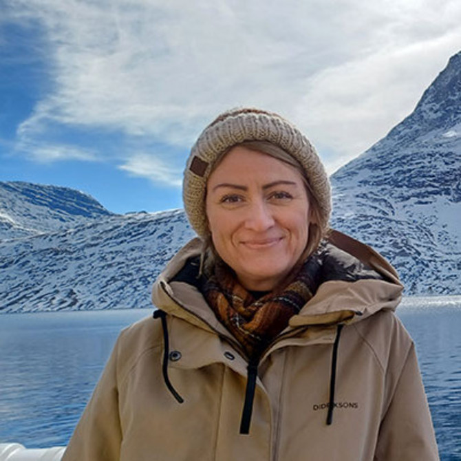 Eine Frau steht vor einem schneebedeckten Berg
