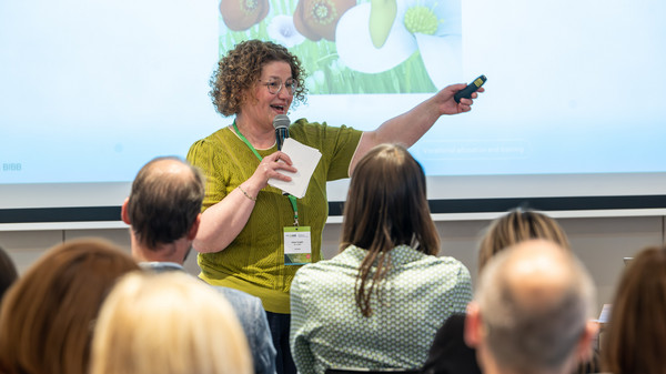 Frau h&auml;lt eine Pr&auml;sentation vor Teilnehmenden ab