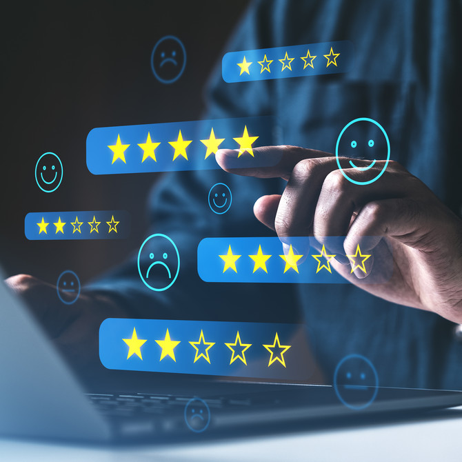 Person interacting with digital customer feedback and star rating icons on a laptop screen. Concept of online reviews and service satisfaction.