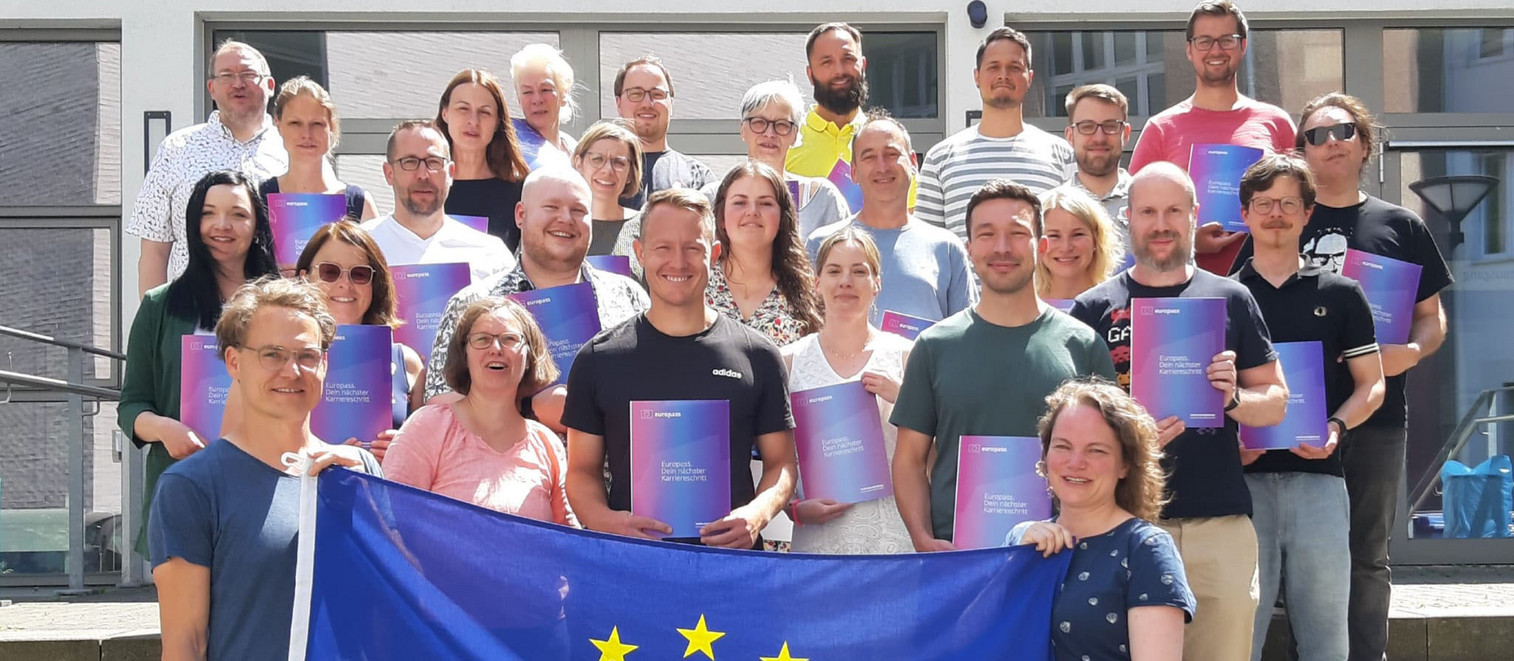 Lehrkräfte mit Europässen und Europaflagge