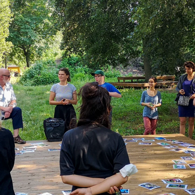 Szene im Freien um ein großes Spielfeld mit Karten
