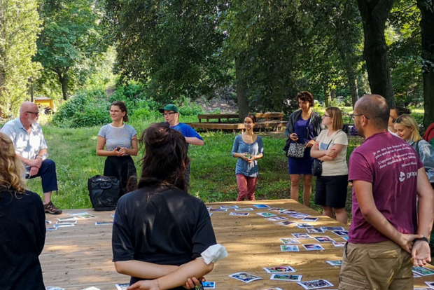 Szene im Freien um ein Spielfeld mit Karten