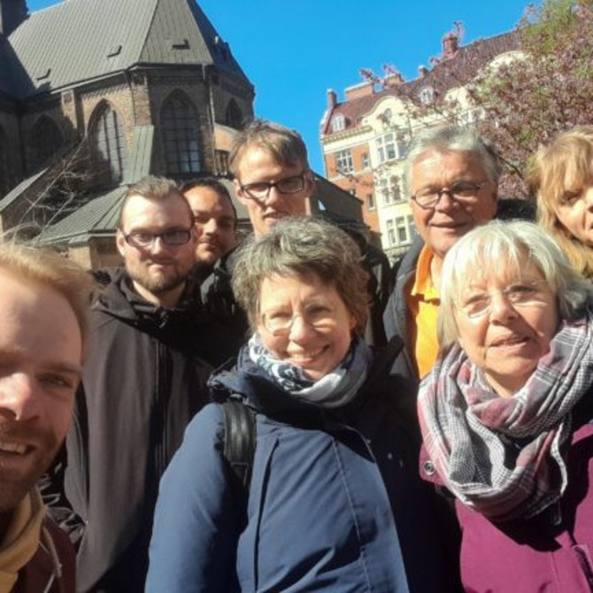 Acht Personen stehen vor einer Kirche