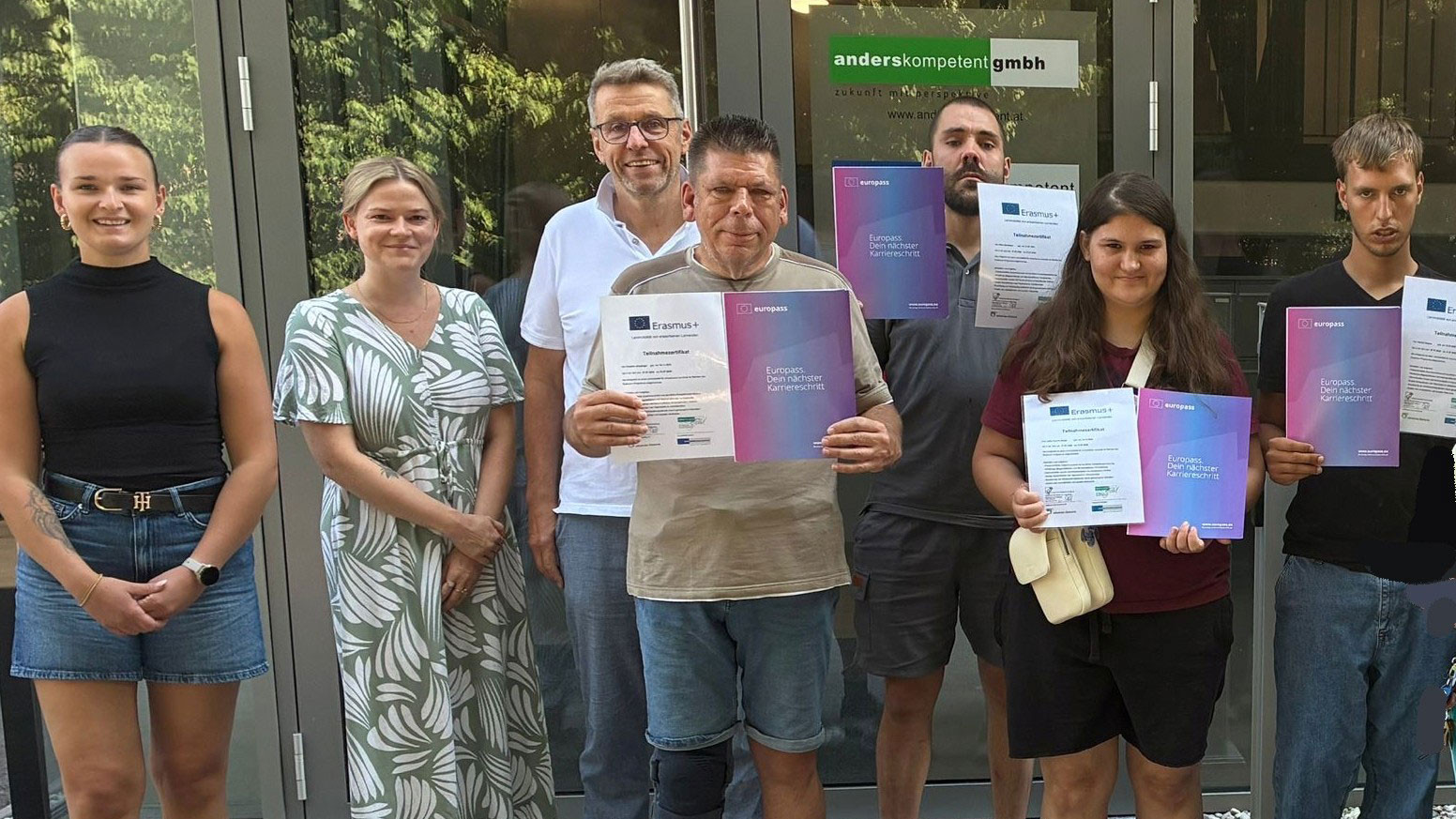 Die Teilnehmenden am Erasmus+-Projekt stehen als Gruppe beisammen und pr&auml;sentieren ihren Europass-Mobilit&auml;tsnachweis
