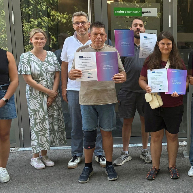 Die Teilnehmenden am Erasmus+-Projekt stehen als Gruppe beisammen und präsentieren ihren Europass-Mobilitätsnachweis