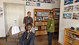 Drei Menschen unterhalten sich in einem Museum