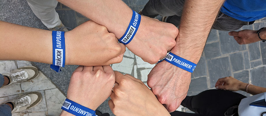 5 F&auml;uste mit einem Armband vom Europ&auml;ischen Parlament bilden einen Kreis