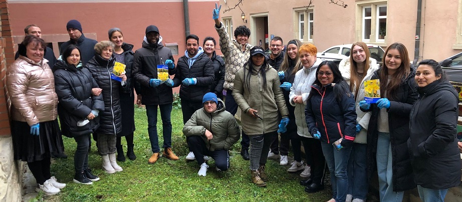 Eine Gruppe Lernender steht in einem Garten