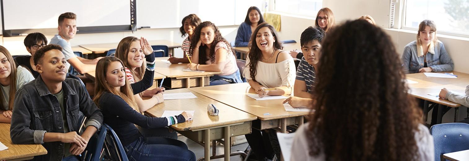 Lehrerin vor Schülerinnen und Schülern in der Klasse