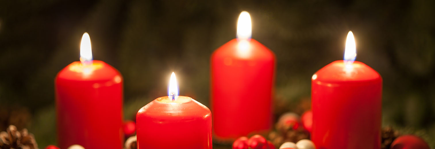 Adventskranz mit vier brennenden Kerzen