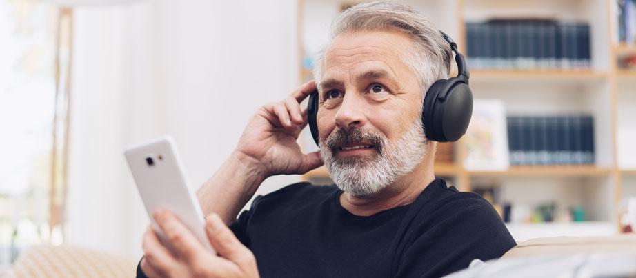 Mann mit Kopfhörern hört interessiert einen Podcast