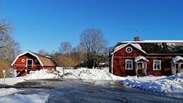 finnische Landschaft mit Häusern im Schnee vor blauem Himmel