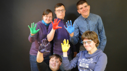 Menschengruppe mit bunt angemalten Handflächen