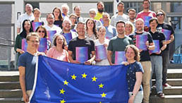 Teilnehmer und Teilnehmerinnen mit EU-Flagge
