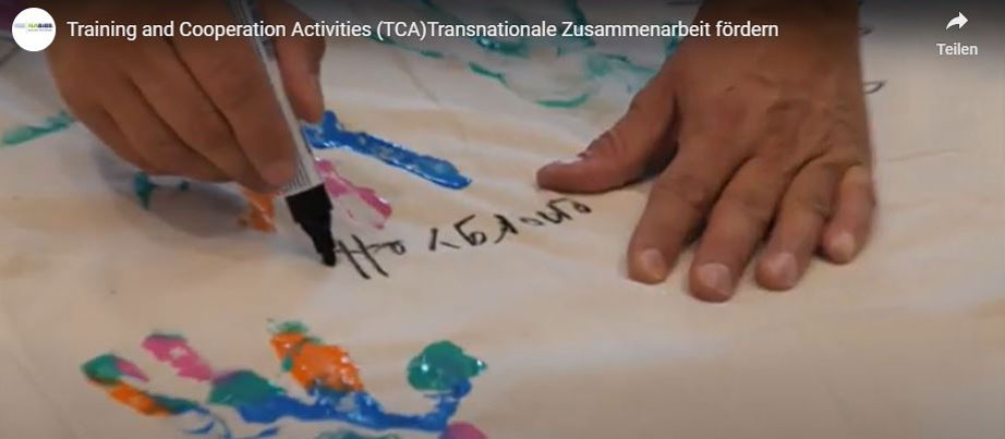 Bild aus dem Video: Hände, die etwas auf Papier schreiben