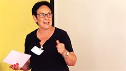 Foto: eine Teilnehmende steht vor der Leinwand und hält einen Zettel in der Hand. Sie schlägt ein Thema vor.